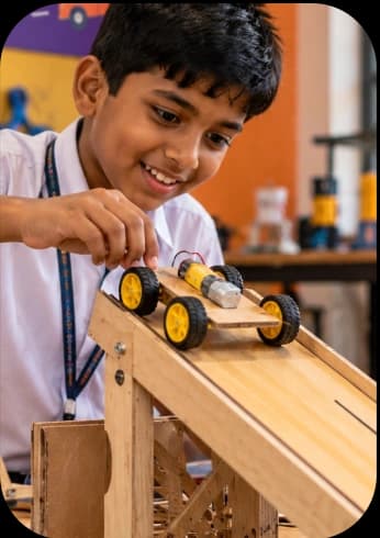 A student exploring motion with a model car and ramp